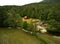 An aerial view of a barn and sawmill by a mountain stream.