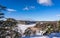 Aerial view of the Bay of the Baltic sea with rocky coasts in winter day. Winter snowy landscape of the Swedish coast on blue sky