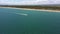 Aerial view of the beach along the coastline. The drone flies forward