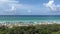 An aerial view of the Beach with Blue Umbrella and Lounge Chairs lined up at the Watercolor Community Club in Watercolor, Florida