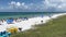 An aerial view of the Beach with Blue Umbrella and Lounge Chairs lined up at the Watercolor Community Club in Watercolor, Florida