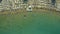 Aerial view of the beach filled with people on a hot sunny day. Sun umbrellas stand in yellow bright sand. People rest