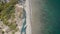 Aerial view of beach, a tropical forest and ocean with waves. Azure beach with rocky mountains and clear water.