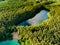 Aerial view of beautiful green waters of lake Gela. Birds eye view of scenic emerald lake surrounded by pine forests