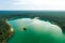 Aerial view of beautiful green waters of lake Gela. Birds eye view of scenic emerald lake surrounded by pine forests. Clouds