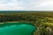 Aerial view of beautiful green waters of lake Gela. Birds eye view of scenic emerald lake surrounded by pine forests. Clouds
