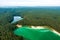 Aerial view of beautiful green waters of lake Gela. Birds eye view of scenic emerald lake surrounded by pine forests. Clouds