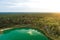 Aerial view of beautiful green waters of lake Gela. Birds eye view of scenic emerald lake surrounded by pine forests. Clouds