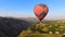 Aerial view of beautiful hot air balloon flying over mountain village, Armenia