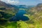 Aerial view of a beautiful lake in a narrow valley surrounded by tall mountains