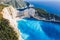 Aerial view of beautiful Navagio or Shipwreck beach on Zakynthos Island, Greece. Tourists on cliff edge enjoy view on