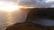 Aerial view of beautiful orange sunset in Faroe Island. Huge cliff and sea stacks glow in golden evening light