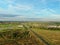 Aerial view beautiful panoramic landscape golden sunset above the forest. The road goes beyond the horizon in the rays of the sun