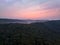 Aerial view of beautiful pink clouds over misty forested landscape