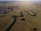 aerial view of a beautiful winding river flows among the fields, which flows picturesquely, creating incredible