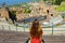 Aerial view of beautiful young woman looking ruins of the ancient Greek theater in Taormina, Sicily Italy