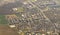 Aerial view below an airplane wing equipped with winglet : flying over residential, suburban and industrial zones of the region of