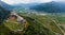 Aerial view of Beseno Castle and northern vineyards, the largest fortified structure in Besenello, Trento, Italy. wide panorama