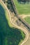 Aerial view of bicycle lane between green fields and lake. spring landscape