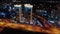 Aerial view. Big city at night with modern buildings, moving cars. Crossing roads. Business center.