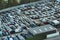 Aerial view of big parking lot of junkyard with rows of discarded broken cars. Recycling of old vehicles