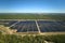 Aerial view of big sustainable electric power plant with many rows of solar photovoltaic panels for producing clean