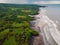 Aerial view of black sand beach with ocean and waves in Balian