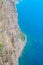 Aerial view of the blue Atlantic ocean and Madeiran coast. Stone beach and adjacent fields on the southern coast of Madeira island