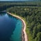 an aerial view of blue lake stone shore and green woods with pine trees.