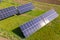 Aerial view of blue photovoltaic solar panels mounted on backyard ground for producing clean ecological electricity. Production of