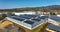 Aerial view of blue photovoltaic solar panels mounted on industrial building roof for producing green ecological