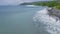 Aerial view blue sea waves and green tropical island landscape. Drone view blue ocean waves splashing on rocky coastline