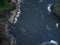 Aerial view. Blue water of the ocean and a rocky shore covered with green moss. The beauty and majesty of nature. Environmental