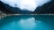 Aerial view on a boat with four tourists floating on turquoise water lake Paron