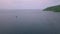 Aerial view of a boat journey in the blue ocean moving towards tropical a island