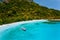 Aerial view of boat moored at secluded tropical beach with white sand, turquoise colored ocean shallow lagoon and