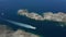 Aerial view of boat sailing along rocky sea coast