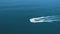 Aerial view of boat speeding over the sea leaving a trail of white foam in its wake