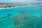 Aerial view of boats anchored off coral rocks with North Bimini in background.