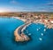 Aerial view of boats and yachts in dock, breakwater and blue sea