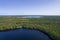 Aerial view of bogs, forests in green, yellow colors and deep blue lakes