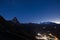 Aerial view of Breuil Cervinia village glowing in the night, famous ski resort in Aosta Valley, Italy. Wonderful starry sky over