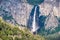 Aerial view of Bridalveil Falls dropping over a colorful rock wall; Yosemite National Park, Sierra Nevada mountains, California