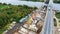 Aerial view of bridge construction at area with two cranes nearby road and river