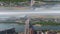 Aerial view of the bridge crossing wide river near a city, mirror horizon effect. Media. Summer landscape with green