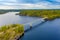 Aerial view of the bridge and island on a blue lake Saimaa. Landscape with drone. Blue lakes, islands and green forests from above