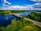 Aerial view on bridge over blue lake in rural Finland countryside with green and yellow fields