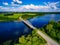 Aerial view on bridge over blue lake in rural Finland countryside with green and yellow fields