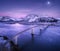 Aerial view of bridge, snow covered mountains, purple sky