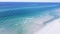 Aerial view brilliantly white sandy shore with crystal-clear turquoise water and gorgeous shade of blue waves along miles of